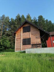 een houten hut met twee ramen aan de zijkant bij Planinska kuća Jabuka in Prijepolje