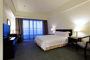 斗六的住宿－華安大飯店，配有一张床和一台平面电视的酒店客房