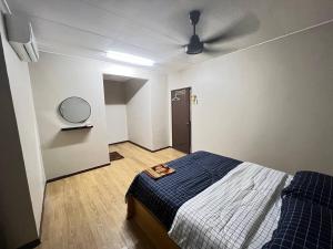 Schlafzimmer mit einem Bett und einem Deckenventilator in der Unterkunft Netflix Wifi (3 Rooms) Homestay Kak Nad Saujana Utama in Sungai Buloh