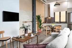 ein Wohnzimmer mit einer Couch und einem Tisch in der Unterkunft Suites Maestranza - Herrería by Magno Apartments in Sevilla