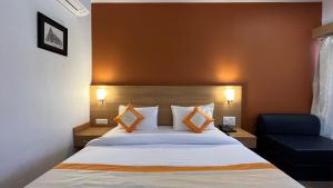 a hotel room with a bed and a blue chair at Hotel The Bundela - Khajuraho, Madhya Pradesh in Khajurāho