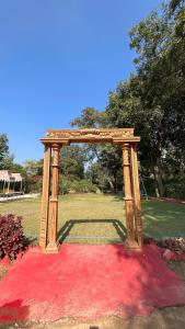 uma estrutura de madeira sentada em cima de um tapete vermelho em Hotel The Bundela - Khajuraho, Madhya Pradesh em Khajuraho
