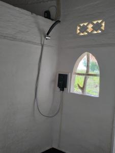 - une douche dans une chambre avec fenêtre dans l'établissement SHAYA cottage, à Sekotong