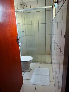 a bathroom with a toilet and a glass shower at Hotel Anápolis in Anápolis