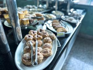 a buffet line with plates of donuts and pastries at Hotel Anápolis in Anápolis