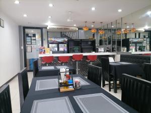 una sala da pranzo con due tavoli e un bar di Amici Miei Guest House a Patong Beach