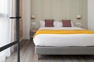 Ein Bett oder Betten in einem Zimmer der Unterkunft Suites Maestranza - Herrería by Magno Apartments