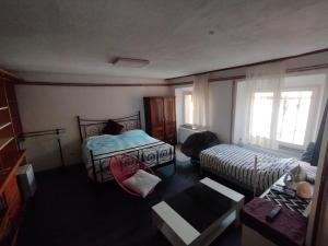 1 dormitorio con 2 camas, mesa y sofá en Lux apartments and rooms Dogs baronesse Idrija en Idrija