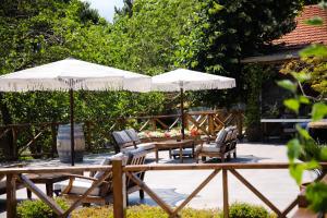 a patio with a table and chairs and umbrellas at MAVİ AT HOTEL Blue Horse in Gümüşdere