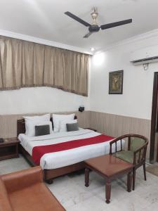 a bedroom with a large bed with a ceiling fan at HOTEL CORPORATE INN in Chandīgarh