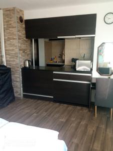 a kitchen with black cabinets and a counter top at Summer SZ Guest House in Sozopol
