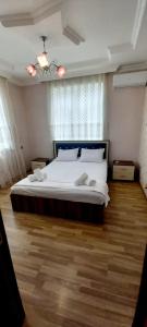 een slaapkamer met een groot bed en een houten vloer bij Red Villa Big swimming pool in Gabala