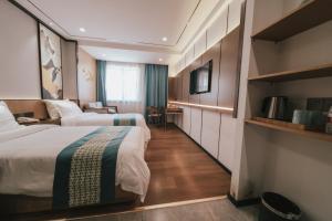 um quarto de hotel com duas camas e uma secretária em Puyue Hotel Hangzhou em Hangzhou