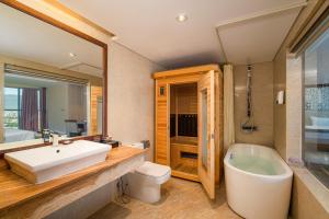 uma casa de banho com um lavatório, uma banheira e um WC. em Luxtery Hotel & Spa em Da Nang
