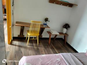 une chaise jaune assise à côté d'un bureau dans une pièce dans l'établissement Căn hộ 2 phòng ngủ, à Ấp Ða Lợi