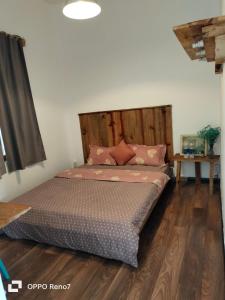 - un lit avec une tête de lit en bois dans l'établissement Căn hộ 2 phòng ngủ, à Ấp Ða Lợi