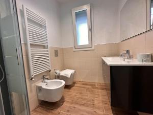 a bathroom with two sinks and a toilet in it at NEW Duomo, Hospital, ENI - Cozy Home in San Donato Milanese