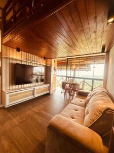 a large living room with a couch and a television at Apartamento aconchegante in Bananeiras