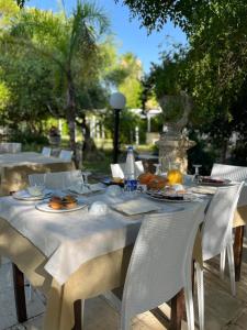 una mesa blanca con platos de comida. en Agriturismo Tenuta la Monaca, en Aradeo