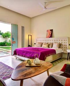 a bedroom with a large bed with a purple bedspread at Parijat Private Pool Villa in Udaipur