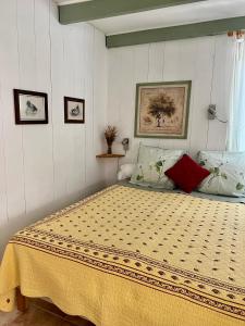 een slaapkamer met een bed met een gele sprei bij Domaine du Lac de la vallée in La Roquette-sur-Siagne