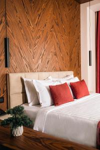 Venus Hotel في بريشتيني: غرفة نوم بسرير ومخدات حمراء وبيضاء