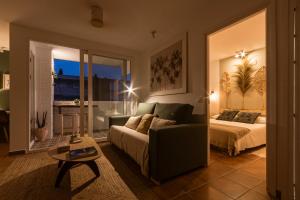 a living room with a bed and a couch and a room with a bed at K-NAT by Nuka Homes in Platja de l'Arenal