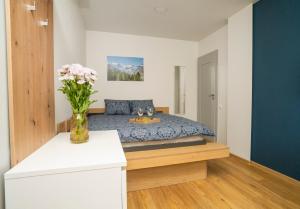 a bedroom with a bed with a vase of flowers at Fort63 apartments in Kaunas