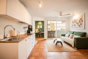 a kitchen and living room with a couch and a table at K-NAT by Nuka Homes in Platja de l'Arenal