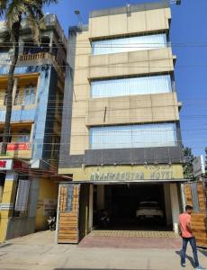 a man walks in front of a building at The Brahmaputra Hotel in Dhuburi