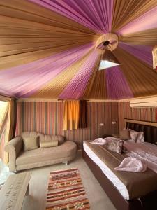 Habitación con 2 camas y techo púrpura. en Marina Wadi Rum Camp en Disah
