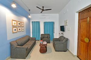 Sala de estar con 2 sofás y mesa en The Lotus Villa, en Kottakupam