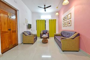 a living room with two couches and a table at The Lotus Villa in Kottakupam