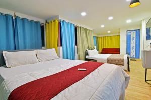a hotel room with two beds and colorful curtains at The Lotus Villa in Kottakupam