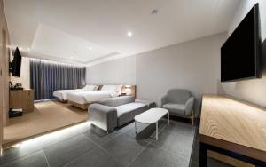 金海市The Van Hotel的一间带床和客厅的酒店房间