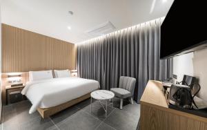 金海市The Van Hotel的配有一张大床和一张书桌的酒店房间