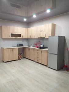 uma cozinha vazia com armários de madeira e um frigorífico em Дом гарах em Bakuriani