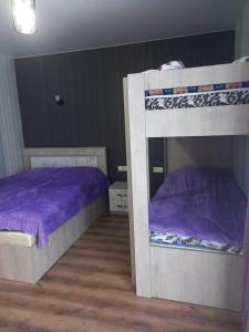 two bunk beds in a bedroom with purple sheets at Дом гарах in Bakuriani