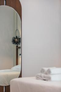 巴利恩的住宿－Del Mare Apts，一间卧室配有一张床、镜子和一张桌子