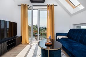 a living room with a blue couch and a tv at Exclusive Apartment Różana with AC & Balcony View 1 km to the Beach by Renters in Sianozety