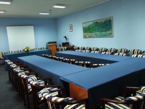 Una sala de conferencias con mesas y sillas azules. en Bed & Breakfast Vila Stanišić, en Požega