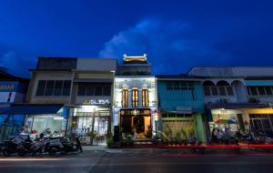 a building on a city street at night at Xinlor House - Phuket Old Town in Phuket