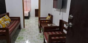 a living room with two chairs and a television at ABODE21 Guesthouse in Balingasay