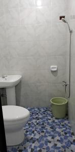a bathroom with a toilet and a sink at ABODE21 Guesthouse in Balingasay