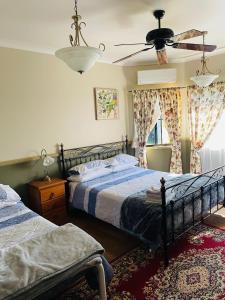 a bedroom with two beds and a ceiling fan at GOLDEN LACE B&B in Sarina