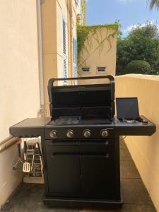 una parrilla negra con un portátil encima en Appartement avec grand jardin, en Cannes