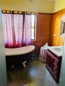 ein Badezimmer mit einer Badewanne und einem Waschbecken in der Unterkunft GOLDEN LACE B&B in Sarina