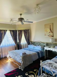 a bedroom with two beds and a ceiling fan at GOLDEN LACE B&B in Sarina