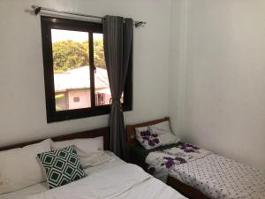a room with two beds and a window at ABODE21 Guesthouse in Balingasay