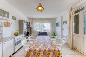 a kitchen with a long table with chairs and a tableasteryasteryasteryasteryastery at Villetta Relax in Castrignano del Capo